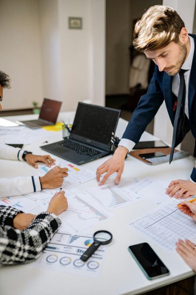 Business meeting with professionals discussing documents at a workplace desk.